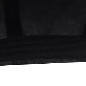 Detailed macro view of black washed cotton fabric with reinforced stitching on baseball cap