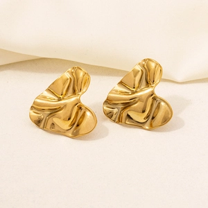 Macro detail of 18k gold plated heart earrings with textured crumpled metal finish