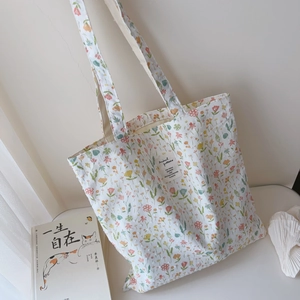 Close-up of floral cotton tote bag showing colorful small flower patterns and fabric label