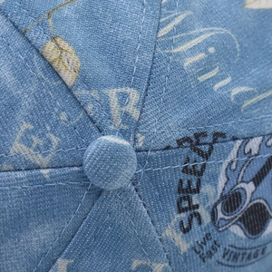 Detailed close-up of blue denim baseball cap crown with vintage SPEED embroidery