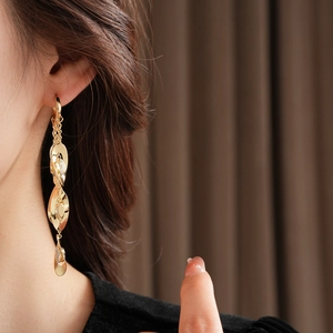 Gros plan de boucles d'oreilles cascade dorées à trois niveaux avec oxydes de zirconium