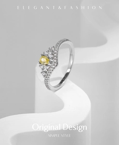 Macro view of crown ring with yellow pear-cut center stone and pave diamond details