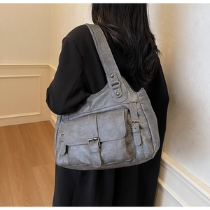Detailed view of grey vintage large capacity tote bag with buckle flap pocket and metal rivets