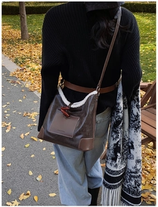 Detail der braunen Vintage-Beuteltasche mit Lammfellbesatz und Holzknöpfen