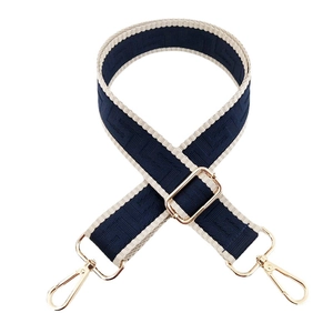 Detail of adjustable wide shoulder strap with blue geometric patterns and gold metal hooks