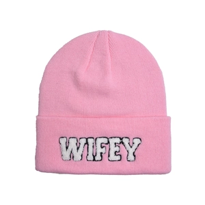 Detailed view of white WIFEY embroidery on a bright pink ribbed knit beanie hat