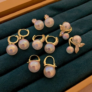 Elegant mermaid pearl earrings with fish tail and zircon details on green velvet tray
