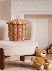 Detail of hand-woven circus tent storage basket with star handle on white cozy sofa