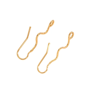 Macro detail of wave shaped gold plated earring hooks with bright metallic finish