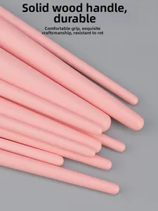 Close-up of pink solid wood makeup brush handles with smooth matte finish and round ends