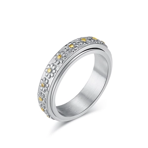 Minimalist spinning daisy ring with silver steel band and golden flower accents