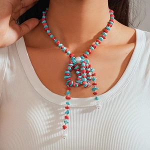 Detail of long beaded necklace with red coral stones, blue turquoise and pearls