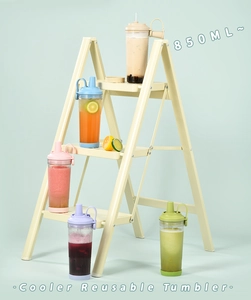 Detailed view of 850ml reusable Tritan tumblers in five colors on a beige ladder