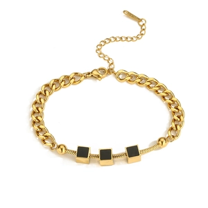 Detail of gold stainless steel bracelet with black square charms and dual chain style