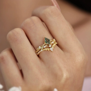 Macro detail of vintage gold moss agate leaf ring set with intricate vine engravings