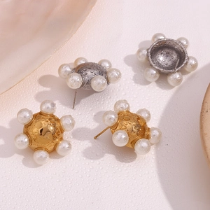 Detailed view of elegant gold and silver wheel stud earrings with multiple inset pearls