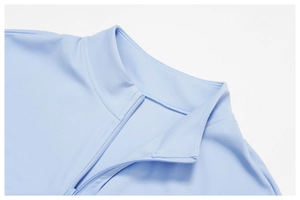 Dettaglio del top sportivo azzurro con collo alto e chiusura a zip in tinta