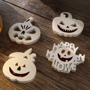 Detailed view of four white Halloween resin molds including 3D carved pumpkin faces