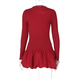 Détail d'une robe rouge à manches longues avec haut en maille et ourlet évasé à volants