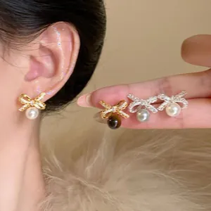 Detailed macro view of 18K gold plated bow earrings with cubic zirconia and pearls