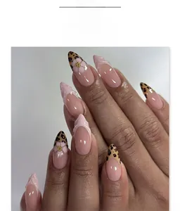 Detail of almond-shaped leopard print nails with pink French tips and floral accents