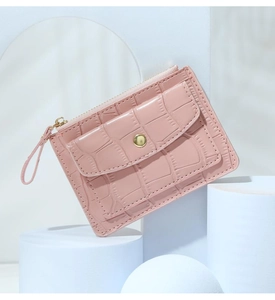 Detailed view of pink crocodile pattern wallet with gold button and zipper closure