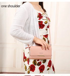 Detail of pink long wallet phone bag with gold metal trim and slim shoulder strap