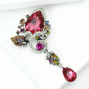 Detailed close-up of pink teardrop crystal brooch with silver floral metal setting