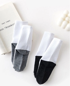 Detail of two-pair set of kids' ribbed crew socks in white, grey, and black color block
