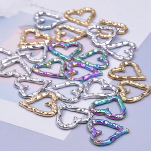 Macro shot of heart-shaped stainless steel connectors in gold, silver, and rainbow colors