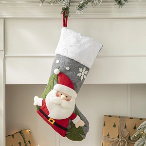Red Santa Claus felt Christmas stocking hanging on a white fireplace with gift boxes