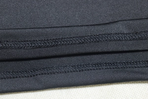 Close-up of double-needle stitching on black mesh patchwork dress fabric detail