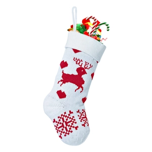 Close-up of red and white knitted Christmas stocking with reindeer and snowflake patterns