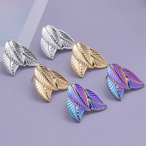 Detailed view of layered feather earrings in silver, gold, and rainbow metallic finishes