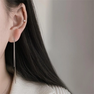 Close-up of minimalist sterling silver long linear drop earrings on a female model