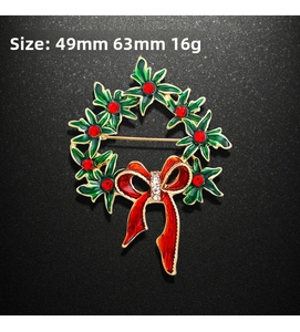 Détail d'une broche couronne de Noël en émail vert avec dimensions de 49mm sur 63mm