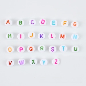 Detailed view of 4x7mm white acrylic alphabet beads with colorful A-Z printed letters