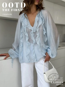 Detail of light blue V-neck chiffon blouse with ruffles and drawstring lantern sleeves