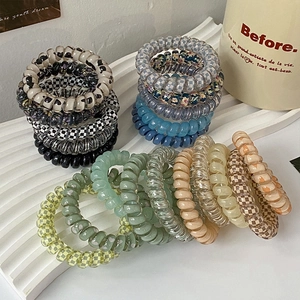 Durable jelly-colored spiral hair ties in various patterns on a decorative tray