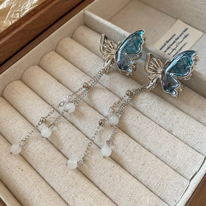 Détail du clip papillon aux ailes translucides et pampilles de perles pour la coiffure