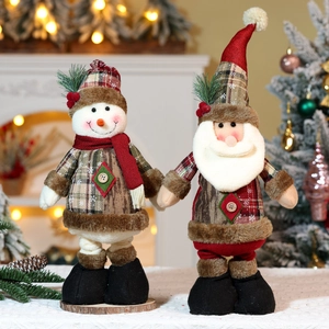 Detailansicht von Plüsch-Weihnachtsmann und Schneemann in Karo-Optik am festlichen Kamin