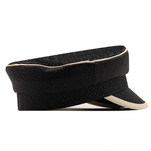 Close-up of black textured leather newsboy cap with ivory contrast trim and pebbled grain