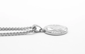 Detailed close-up of a silver stainless steel round medallion pendant with box chain