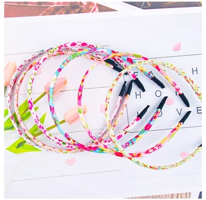 Close-up of four floral fabric wrapped headbands for girls in pink and yellow colors