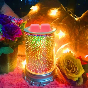 Detail of pink scented wax melts on a glass colorful firework effect burner with metal base
