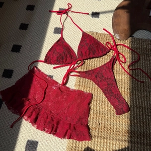 Vue détaillée du bikini en dentelle rouge trois pièces avec une mini-jupe à volants
