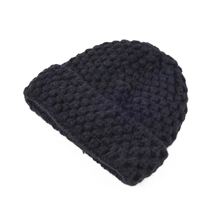 Close-up of thick pineapple texture on a warm black knitted beanie for children