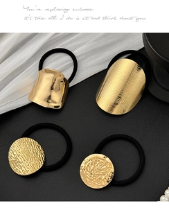 Detail von vier geometrischen goldenen Haargummis mit gebürsteter Textur und elastischem Band