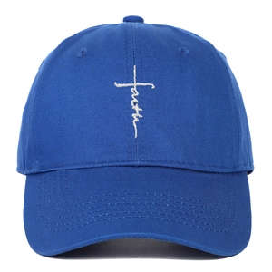 Detail of white faith cross embroidery on a dark blue cotton twill baseball cap