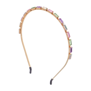Detailed macro view of gold metal headband with colorful inlaid rectangular crystals